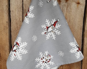 May include: Gray kitchen towel with a white snowflake pattern and red and white gnomes.
