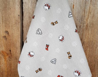May include: A beige kitchen towel with a repeating pattern of white snowflakes, red gnomes, and brown foxes.