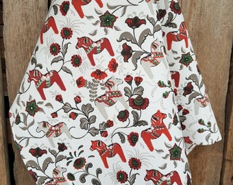 May include: White kitchen towel with a red and brown pattern of stylized horses and flowers.
