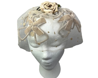 Sombrero de novia tipo pastillero con velo de alambre y roseta de lunares estilo años 50, ideal para el Derby.