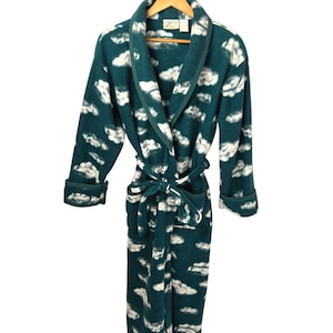 May include: A teal blue fleece robe with a white cloud pattern. The robe has a shawl collar, a tie belt, and long sleeves.