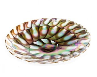 May include: A large, iridescent glass bowl with a swirling, shell-like pattern in shades of brown, white, and green.