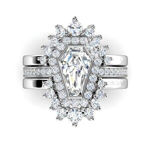 May include: A silver ring set with a large, clear, octagon-shaped diamond surrounded by smaller diamonds. The ring is set on a band with a delicate diamond-studded design.