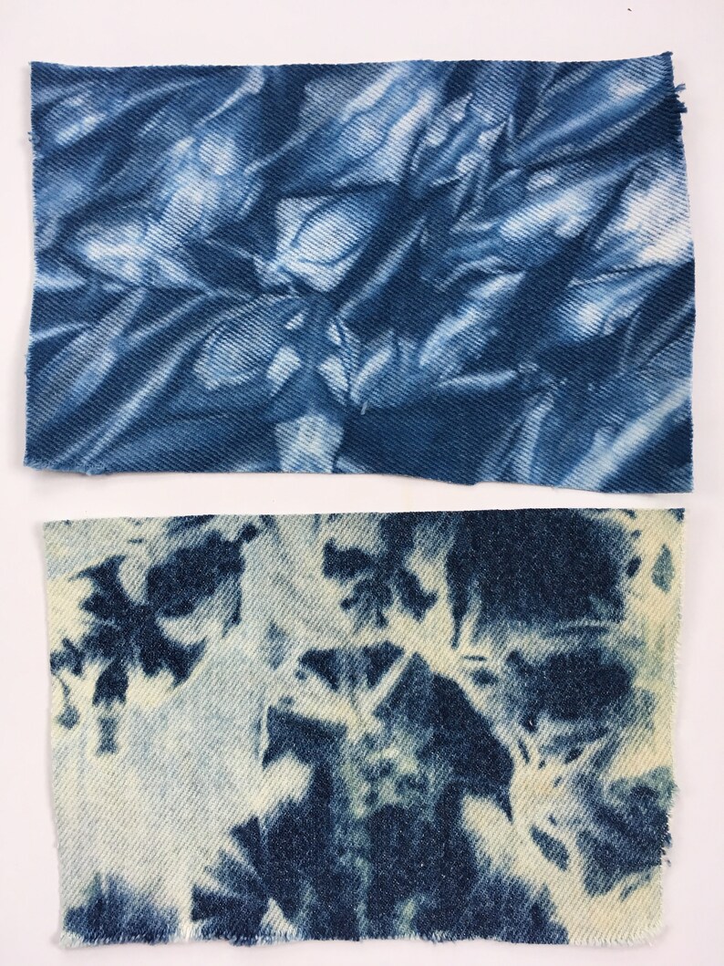 May include: Two pieces of blue denim fabric with a tie-dye pattern. The top piece has a darker blue color and a more abstract pattern. The bottom piece has a lighter blue color and a more floral pattern.