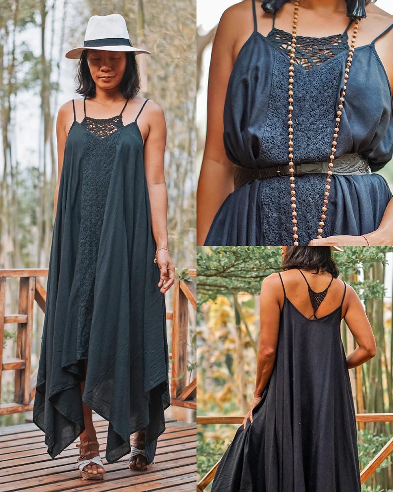 Op de afbeelding: Een zwarte maxi-jurk met spaghettibandjes en een lijfje met kant. De jurk heeft een asymmetrische zoom en wordt gedragen met een hoed met brede rand. De jurk is gemaakt van een lichte stof, ideaal voor warm weer.