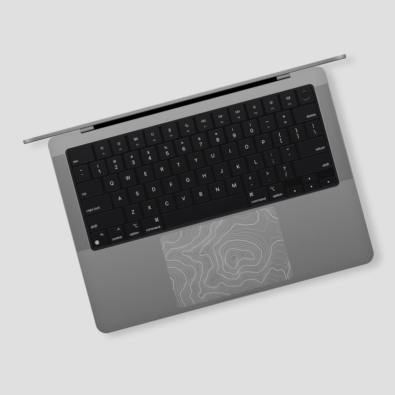 May include: A silver laptop computer with a black keyboard and a trackpad with a topographic map design.