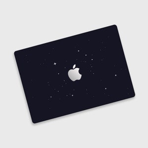 May include: A black laptop with a white Apple logo and a starry night sky design.