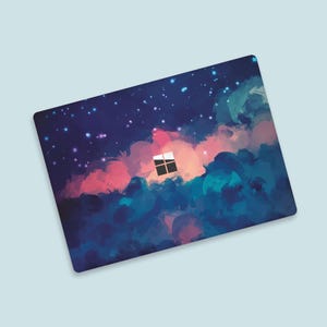 Puede incluir: Una piel para portátil con un diseño de acuarela de un cielo nocturno con nubes y estrellas. El diseño presenta una pequeña ventana en el centro de la imagen.