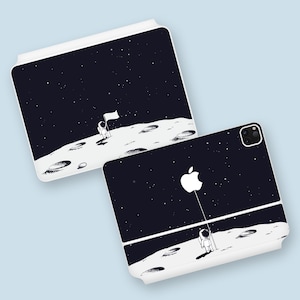 May include: Two white phone cases featuring a black and white astronaut design. The astronaut is standing on the moon with a flag. The background is a starry night sky.