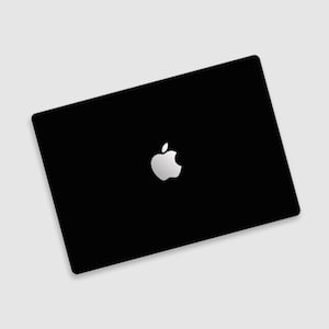 Könnte beinhalten: Ein schwarzer Laptop mit einem weißen Apple-Logo in der Mitte.