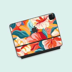 Puede incluir: Una funda de teléfono negra con un diseño floral con flores rojas, naranjas, amarillas, rosas y blancas. La funda tiene un recorte para el objetivo de la cámara.