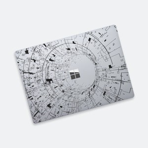 May include: A grey laptop skin with a black and white design of a swirling tunnel with a Microsoft logo in the centre.