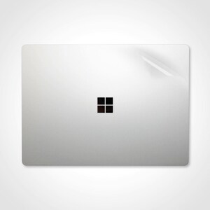 May include: A silver laptop with a black Windows logo on the lid.