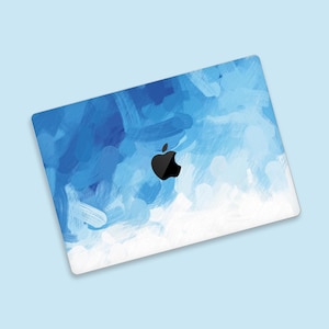 May include: Blue and white abstract paint design laptop skin with a black Apple logo.