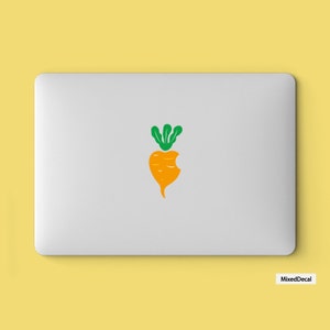 May include: A white laptop with a green and orange sticker of a carrot with a bite taken out of it.