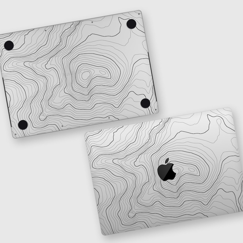May include: A white laptop skin with a black and white topographic map design. The skin is designed to fit a laptop with an Apple logo.