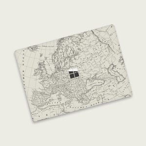 May include: A rectangular laptop skin featuring a detailed, vintage map of Europe in shades of cream and black. The map includes geographical details and text, with a small, black and white square design in the center.