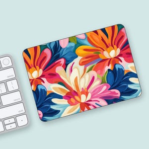 Könnte beinhalten: Eine farbenfrohe Laptop-Haut mit einem floralen Design mit leuchtend pinken, orangen, gelben, blauen und weißen Blumen.