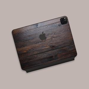 Peut inclure: Une coque de téléphone en bois brun foncé avec un logo Apple noir et un objectif d'appareil photo noir.