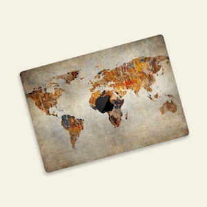 May include: A vintage-style world map laptop skin with a distressed, textured background. The map is in shades of brown, orange, yellow, and blue, with a black Apple logo in the center.
