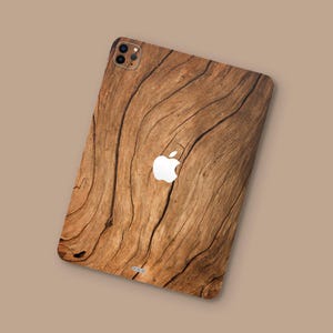 Op de afbeelding: Een telefoonhoesje met een houtnerfpatroon. Het hoesje heeft een bruin en beige houtnerfpatroon en een wit Apple-logo.