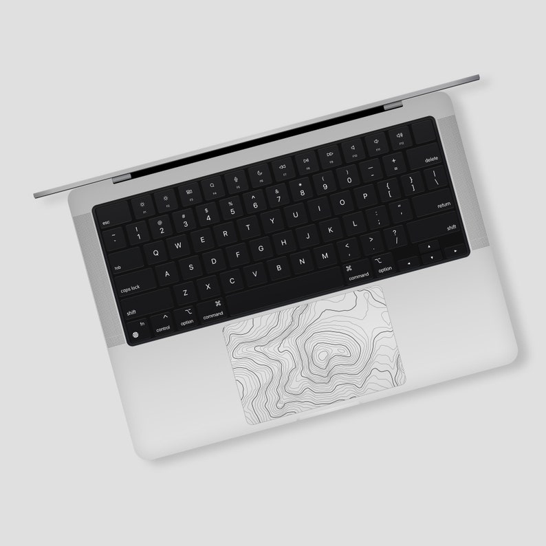 May include: A silver laptop computer with a black keyboard and a topographic map design on the trackpad.