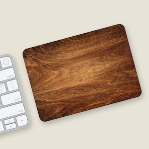 May include: A brown wood grain mousepad with a smooth surface. The mousepad is rectangular and has a light brown border.