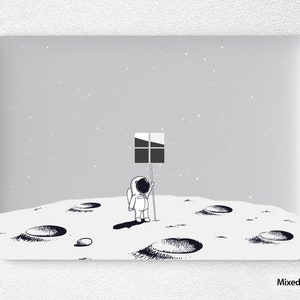 May include: A black and white illustration of an astronaut standing on the moon, holding a flag with a window icon. The moon is depicted with craters and a starry sky background.
