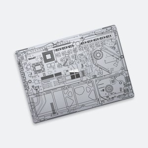 Könnte beinhalten: Eine graue Laptop-Haut mit einem Schaltkreis-Design. Die Haut zeigt eine stilisierte Illustration eines Motherboards mit verschiedenen Komponenten, darunter eine CPU, RAM und eine Festplatte. Der Text "SkinAT" ist in der oberen linken Ecke des Designs sichtbar.