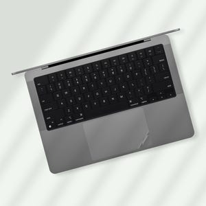 a laptop computer with a black keyboard on a white surface