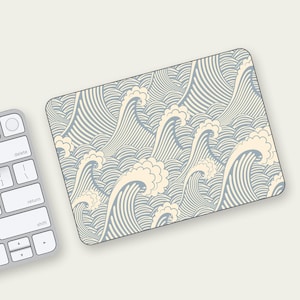 May include: A blue and white mousepad with a repeating pattern of stylized waves. The waves are outlined in white and filled with a light blue color.