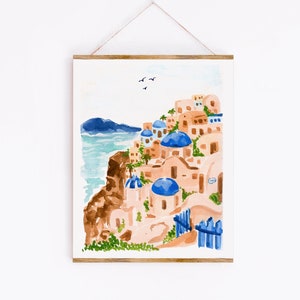 Puede incluir: Pintura acuarela de un pueblo griego blanco y azul en un acantilado con vistas al mar. Los edificios tienen techos abovedados azules y est&aacute;n pintados en tonos de rosa y blanco. El mar es de color azul claro y hay algunas aves volando en el cielo.