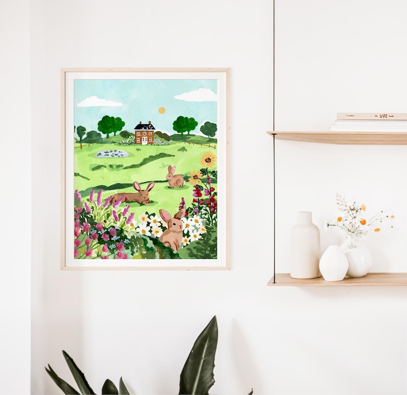 May include: A watercolor painting of a green field with a small house in the background. There are three brown rabbits in the field, surrounded by pink and yellow flowers.
