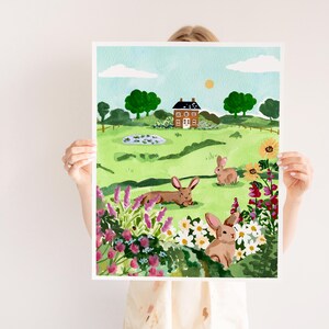 May include: A watercolor painting of a countryside scene with a brown house, green grass, a pond, and three brown rabbits. The painting features a variety of flowers in shades of pink, purple, red, and yellow.