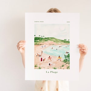 May include: A watercolor illustration of a beach scene with people swimming, sunbathing, and surfing. The beach is surrounded by green hills and palm trees. The text "La Plage" is written at the bottom of the illustration.