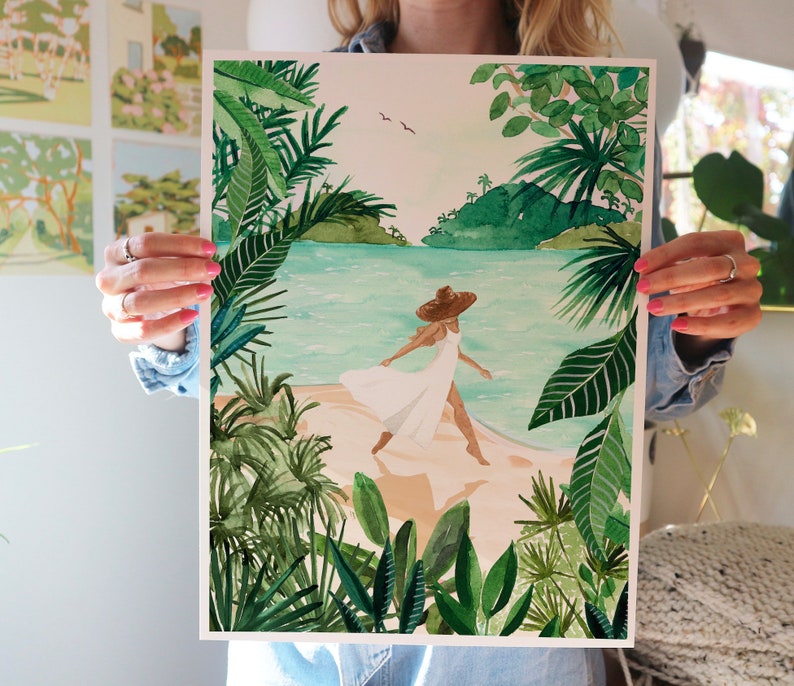 May include: A watercolor painting of a woman in a white dress and a straw hat walking on a beach with lush green foliage in the background.
