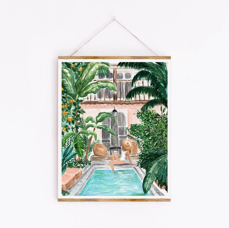 K&ouml;nnte beinhalten: Ein Aquarellbild einer Frau, die sich an einem Pool in einem &uuml;ppigen Innenhof entspannt. Der Pool ist von tropischen Pflanzen und einem rosafarbenen Geb&auml;ude mit Balkon umgeben. Die Frau tr&auml;gt einen wei&szlig;en Badeanzug und einen Strohhut.