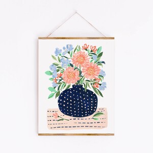 Puede incluir: Un jarr&oacute;n azul y blanco con lunares con un ramo de flores rosas y azules sobre una superficie a rayas rosa y blanca.
