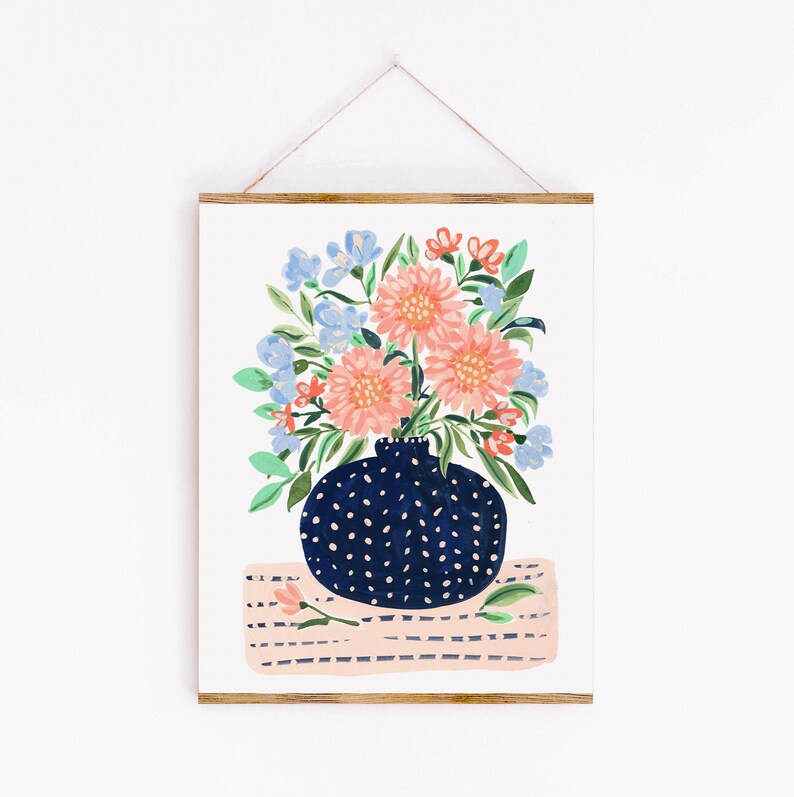 Puede incluir: Un jarr&oacute;n azul y blanco con lunares con un ramo de flores rosas y azules sobre una superficie a rayas rosa y blanca.