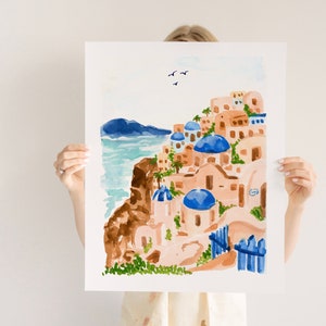 Puede incluir: Pintura acuarela de un pueblo griego blanco y azul con edificios de c&uacute;pula azul en un acantilado con vistas al mar. La pintura tiene un cielo azul claro con algunas aves blancas volando.