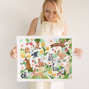 May include: A watercolor print featuring a whimsical design of various rabbits amidst flowers and strawberries. The artwork showcases a light, airy color palette with soft greens, pinks, and yellows, creating a cheerful, spring-like aesthetic.