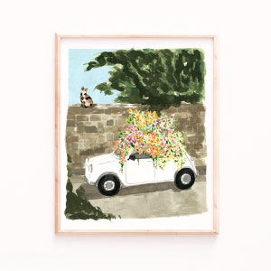 K&ouml;nnte beinhalten: Ein wei&szlig;es Auto mit einem gro&szlig;en Strau&szlig; bunter Blumen auf dem Dach. Eine Katze sitzt im Hintergrund auf einer Steinmauer.