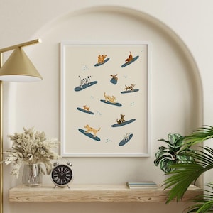 K&ouml;nnte beinhalten: Ein wei&szlig;er gerahmter Druck mit hellbeigefarbenem Hintergrund, der eine skurrile Illustration von Hunden zeigt, die auf blauen und wei&szlig;en Wellen surfen. Die Hunde sind verschiedener Rassen und Farben, darunter braun, wei&szlig;, schwarz und Dalmatiner.