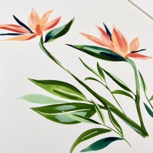 以下が含まれることがあります： オレンジ色の極楽鳥花と緑の葉を描いた水彩画です。