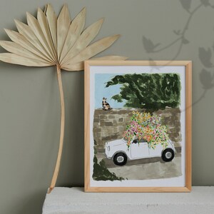 K&ouml;nnte beinhalten: Ein wei&szlig;es Auto mit einem Blumenarrangement auf dem Dach, geparkt vor einer Steinmauer. Eine Katze sitzt auf der Mauer hinter dem Auto. Die Szene ist in einem verspielten Stil mit leuchtenden Farben gemalt.