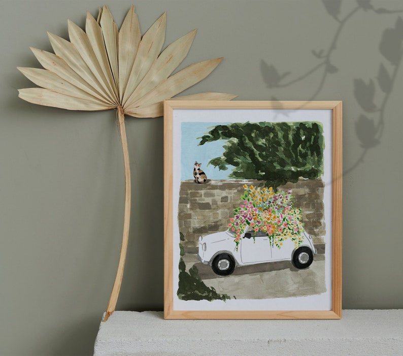 K&ouml;nnte beinhalten: Ein wei&szlig;es Auto mit einem Blumenarrangement auf dem Dach, geparkt vor einer Steinmauer. Eine Katze sitzt auf der Mauer hinter dem Auto. Die Szene ist in einem verspielten Stil mit leuchtenden Farben gemalt.