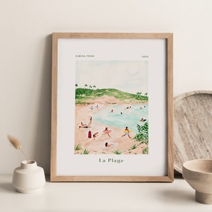May include: A watercolor painting of a beach scene with people swimming and sunbathing. The painting is framed in a light wood frame and has the text "La Plage" at the bottom.