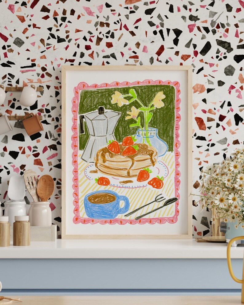 K&ouml;nnte beinhalten: Gerahmte Buntstiftzeichnung einer Fr&uuml;hst&uuml;cksszene. Das Kunstwerk zeigt Pfannkuchen mit Erdbeeren, eine Kaffeekanne, eine blaue Tasse und eine Blumenvase. Der Rahmen hat einen rosa, gewellten Rand und steht vor einer gemusterten Wand.