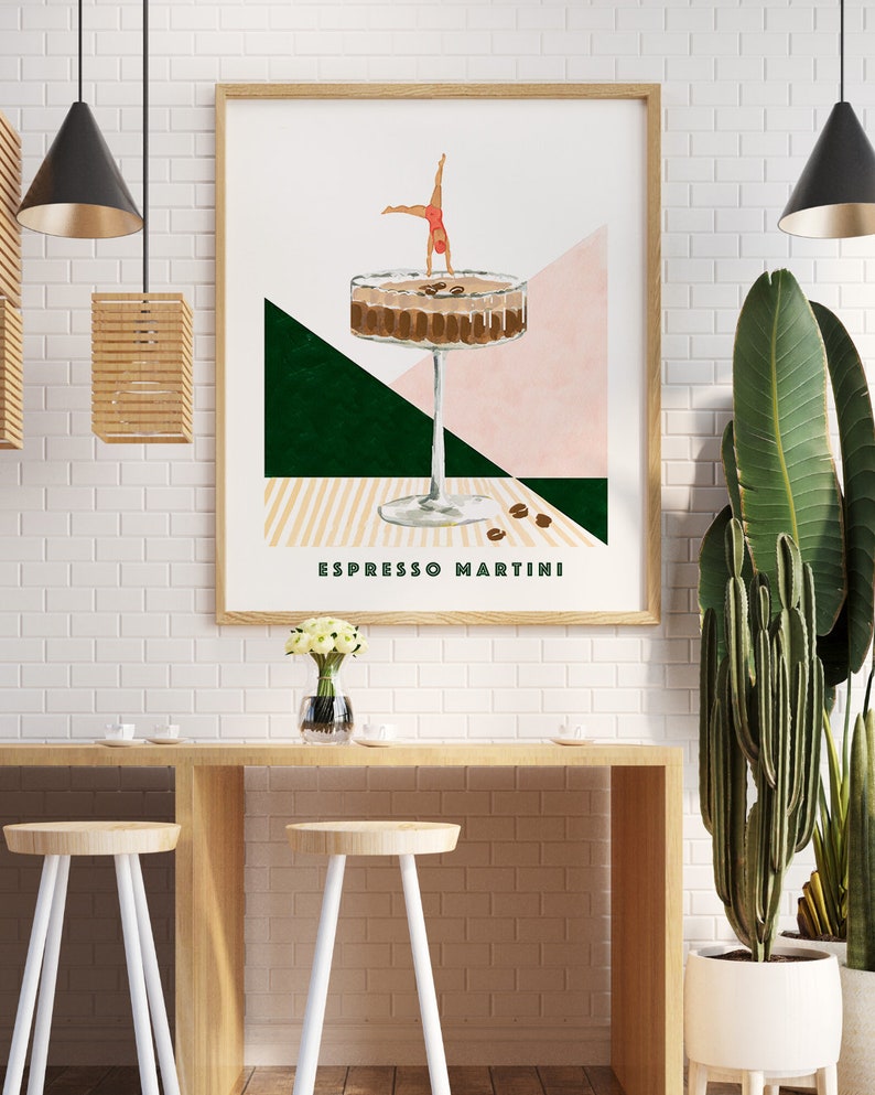 May include: A minimalist poster with a geometric design featuring a martini glass filled with coffee and a woman doing a handstand on top of the glass. The text "Espresso Martini" is printed below the glass.
