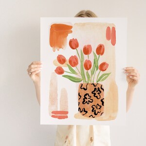 Puede incluir: Una pintura de acuarela de un ramo de tulipanes rojos en un jarr&oacute;n de color marr&oacute;n y negro con estampado. El fondo es de color beige claro con formas abstractas en tonos naranja y rojo.